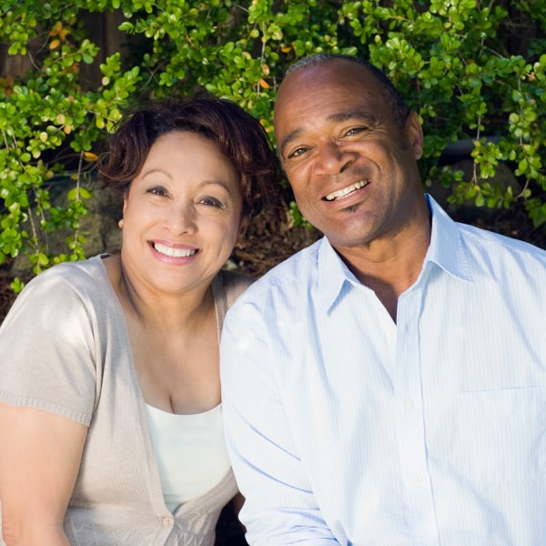 A mature couple smiling with their dental crowns