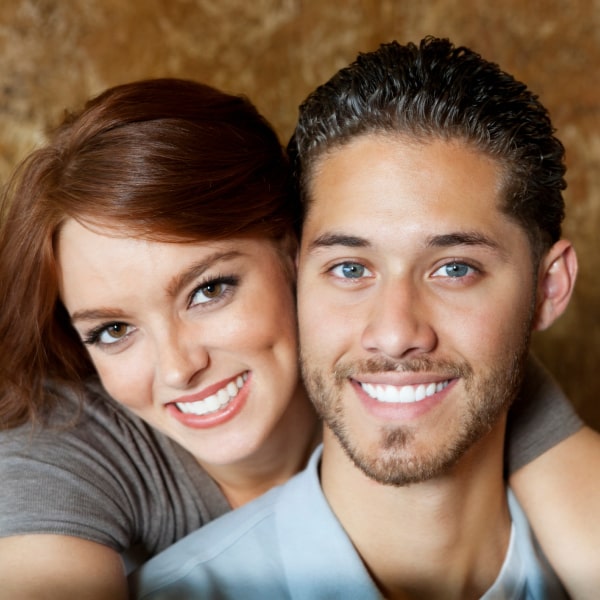 A young couple smiling and huging